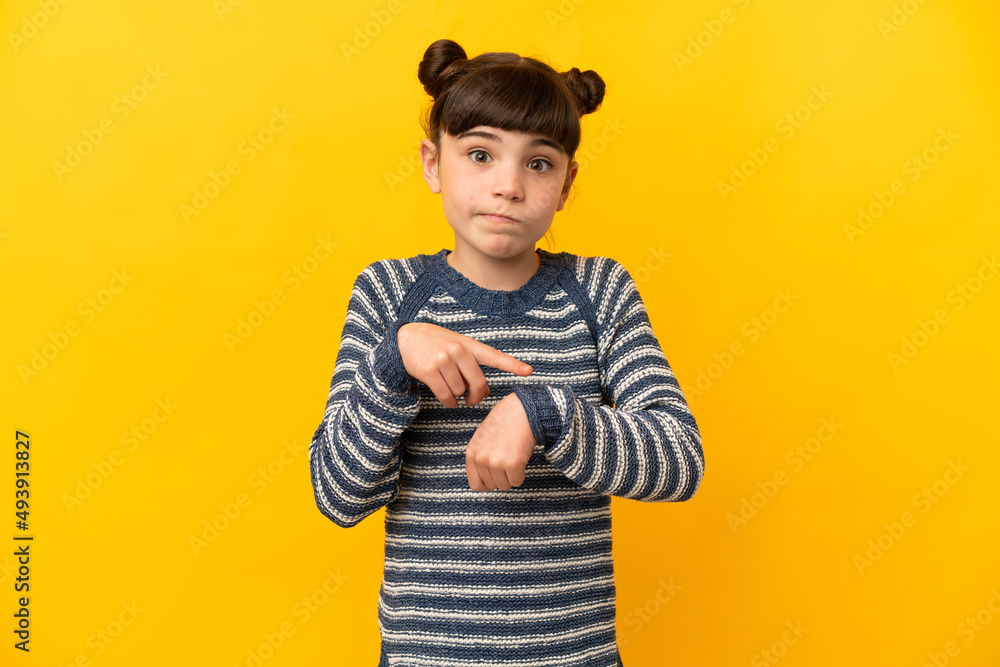 Little caucasian girl isolated on yellow background making the gesture of being late Little caucasian girl isolated on yellow background making the gesture of being late