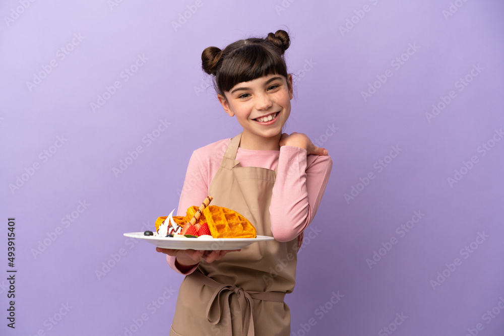 Little caucasian girl holding waffles isolated on purple background laughing Little caucasian girl holding waffles isolated on purple background laughing
