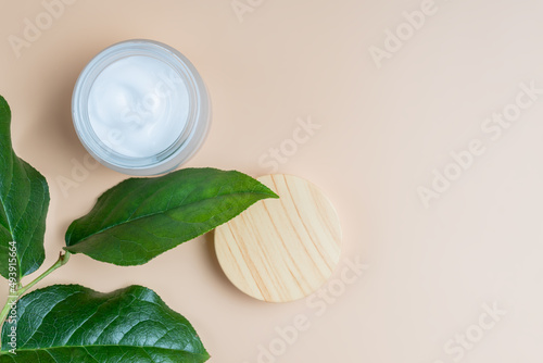 Top view of open glass jar with face cream. Skin care treatment with natural ingredients. Concept of natural cosmetics.