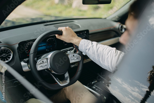 Man holding steering wheel sitting in electric car photo