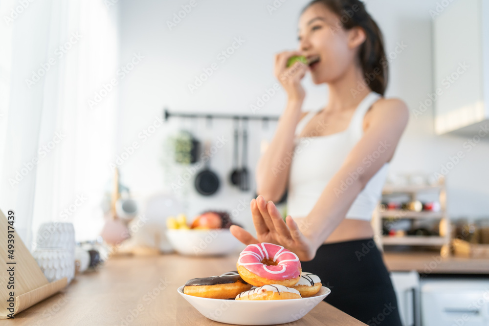 Asian attractive active woman pick up a green apple in kitchen at home. 