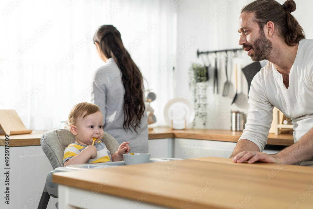 Caucasian young baby toddler eating healthy foods in kitchen at home. Caucasian young baby toddler eating healthy foods in kitchen at home.