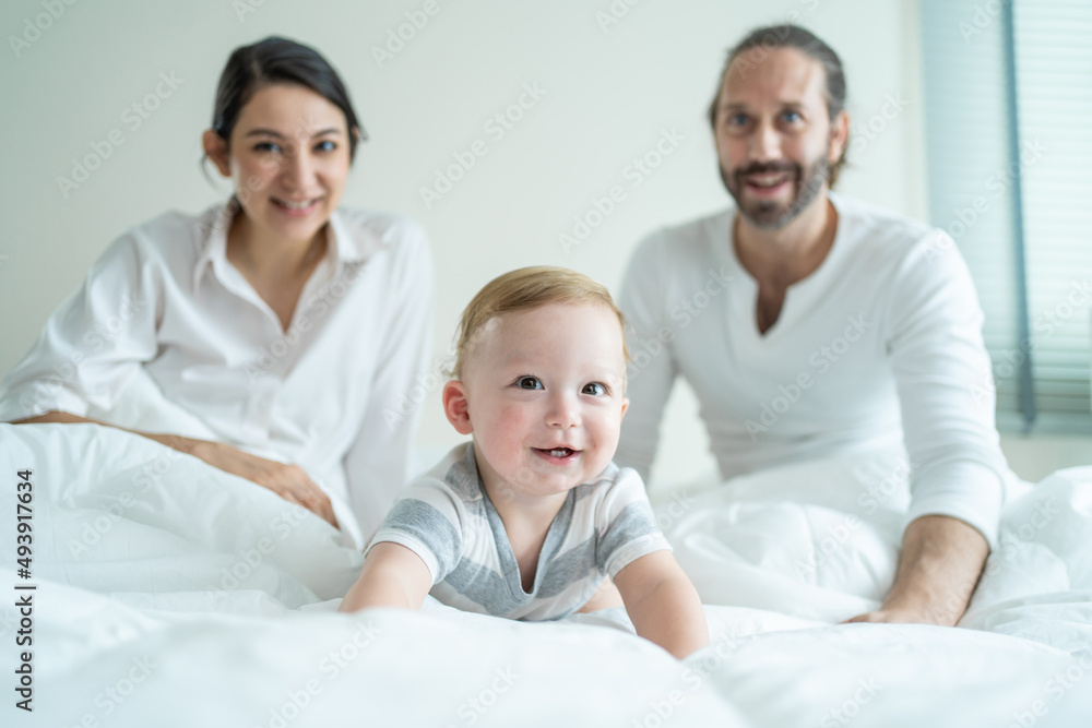 Portrait of Caucasian happy family smiling, look at camera in bedroom. 