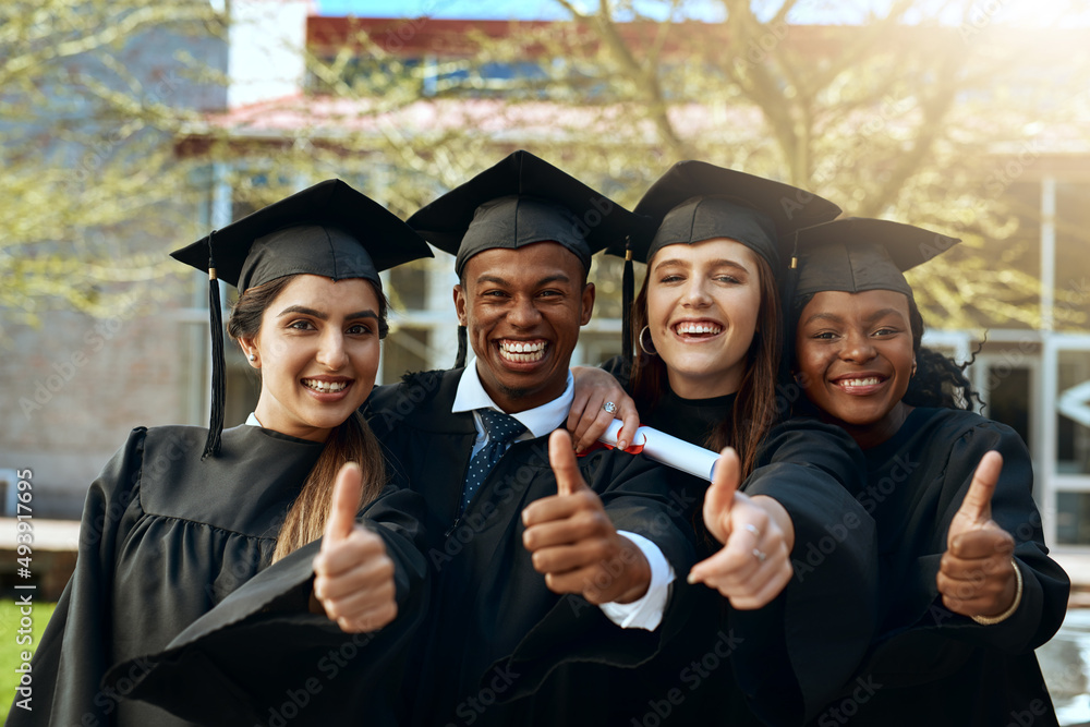 Obraz premium If we can so can you. Portrait of a group of young students showing thumbs up on graduation day.