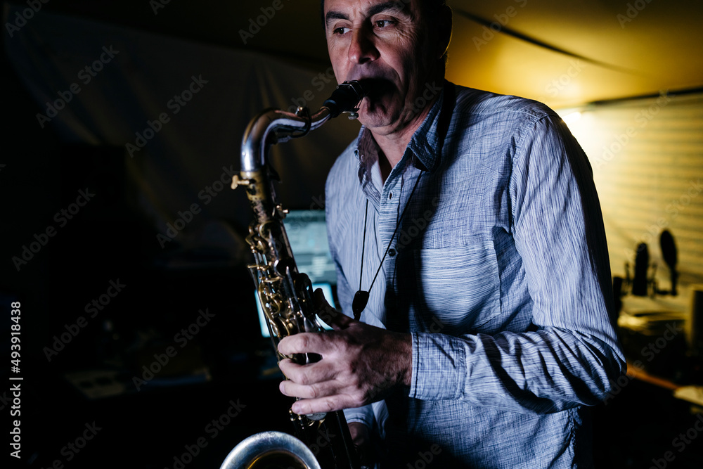 © Westend61 - Musician playing saxophone practicing in recording studio