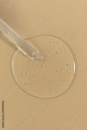 The texture of serum or oil with a pipette on a beige background. Wellness and beauty concept