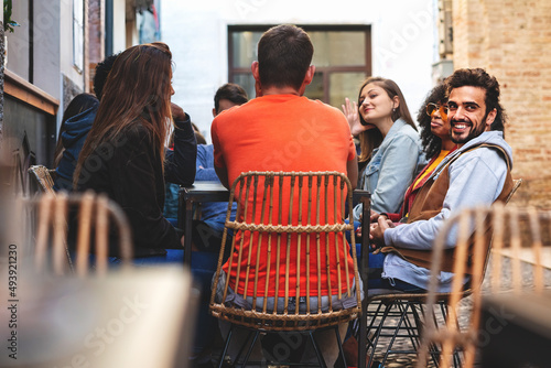 Obraz na plátně Group of young people sitting outdoors at cafe - friends having fun on weekend t