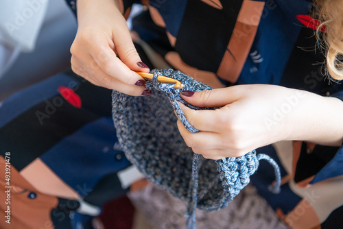 A knitting woman , A woman's hands holding a woolen bag , the woman is carrying a bag , high-end fashion , Happy beautiful young stylish woman , Woman is holding bag , Women is holding handbag 