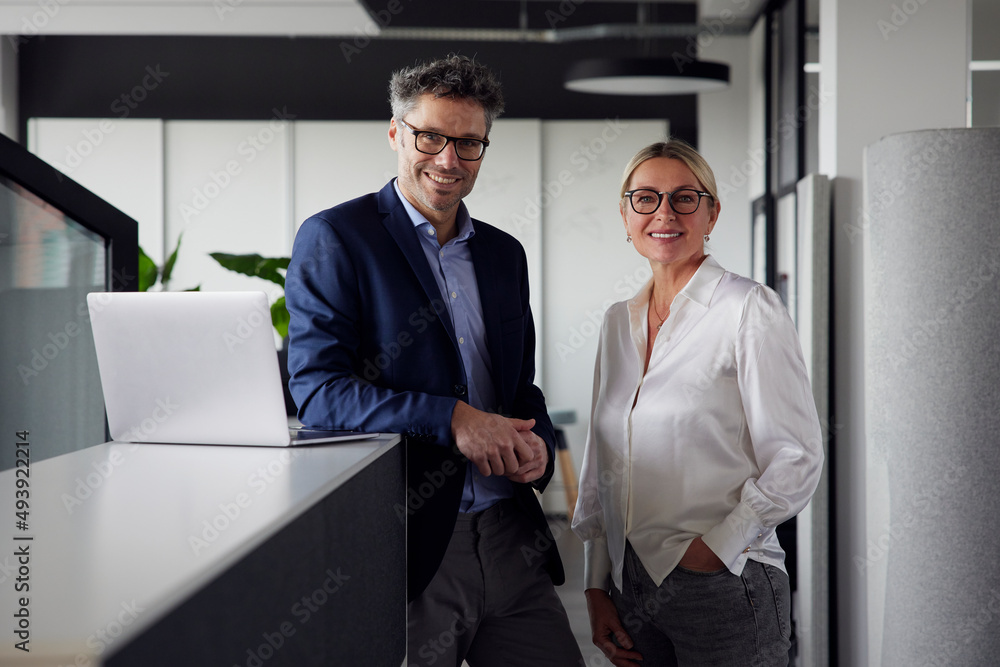 Confident business colleagues standing together in office Confident business colleagues standing together in office