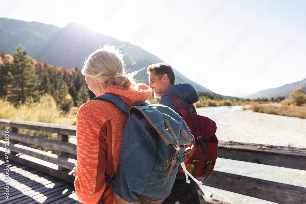 Austria, Alps, couple on a hiking trip crossing a bridge Austria, Alps, couple on a hiking trip crossing a bridge