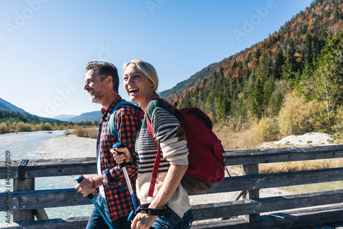 Austria, Alps, happy couple on a hiking trip crossing a bridge