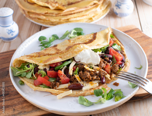 Savory crepe filled with spicy ground beef, vegetables, kidney beans, cheese and sour cream