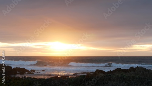 Rocky craggy pacific ocean coast, sea water waves crashing, 17-mile drive, Monterey California USA. Dramatic sunset sky nature near Point Lobos, Big Sur and Pebble beach. Seamless looped cinemagraph.