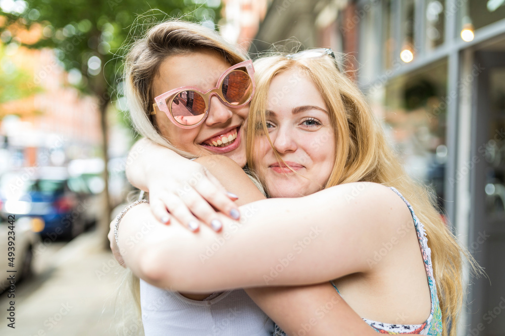 Happy teenage girls with blond hair hugging each other Happy teenage girls with blond hair hugging each other