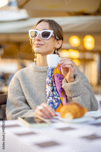 Canvas Print Woman having breakfast with croissant and coffee at traditional italian cafe outdoor