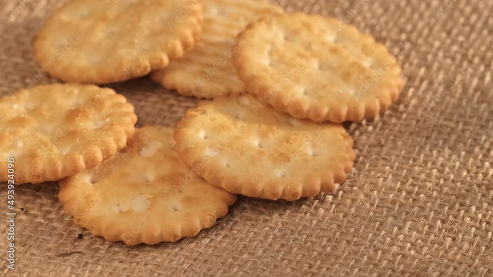 Circle crackers with salt. Close up. Rotating cracker cookies background. Tasty food. Beautiful round crackers on canvas Circle crackers with salt. Close up. Rotating cracker cookies background. Tasty food. Beautiful round crackers on canvas