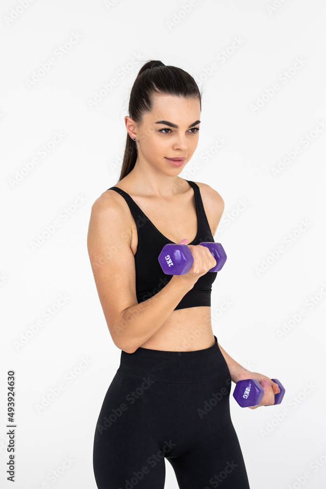 Fototapeta premium Young woman with dumbbell fit slim abs body isolated on a white background. Healthy lifestyle.