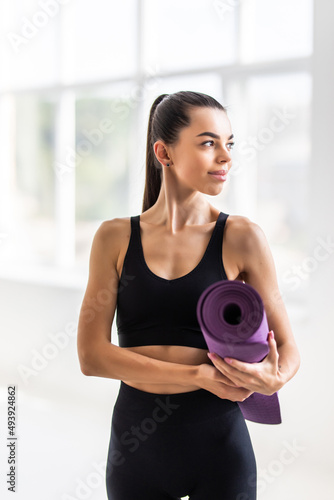 Beautiful young woman with a yoga mat at the gym © dianagrytsku