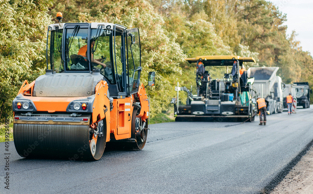 Vibratory asphalt rollers compactor compacting new asphalt pavement. Road service repairs the highway Vibratory asphalt rollers compactor compacting new asphalt pavement. Road service repairs the highway