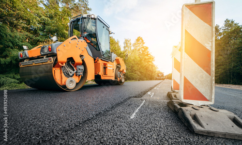 Vibratory asphalt rollers compactor compacting new asphalt pavement. Road service repairs the highway photo