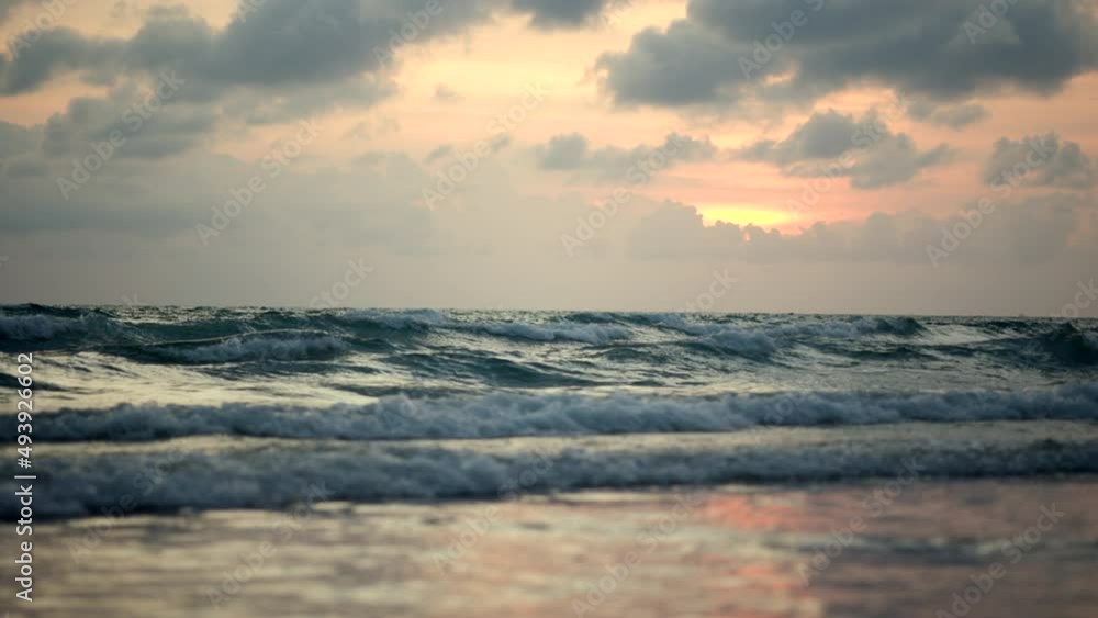 Slow motion amazing sunrise ripple ocean waves. Beautiful yellow serene scene over sea with sunlight reflect on water surface. Nature background.
