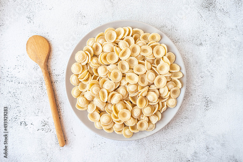 Fotografía Dry uncooked orecchiette Italian pasta on grey concrete background