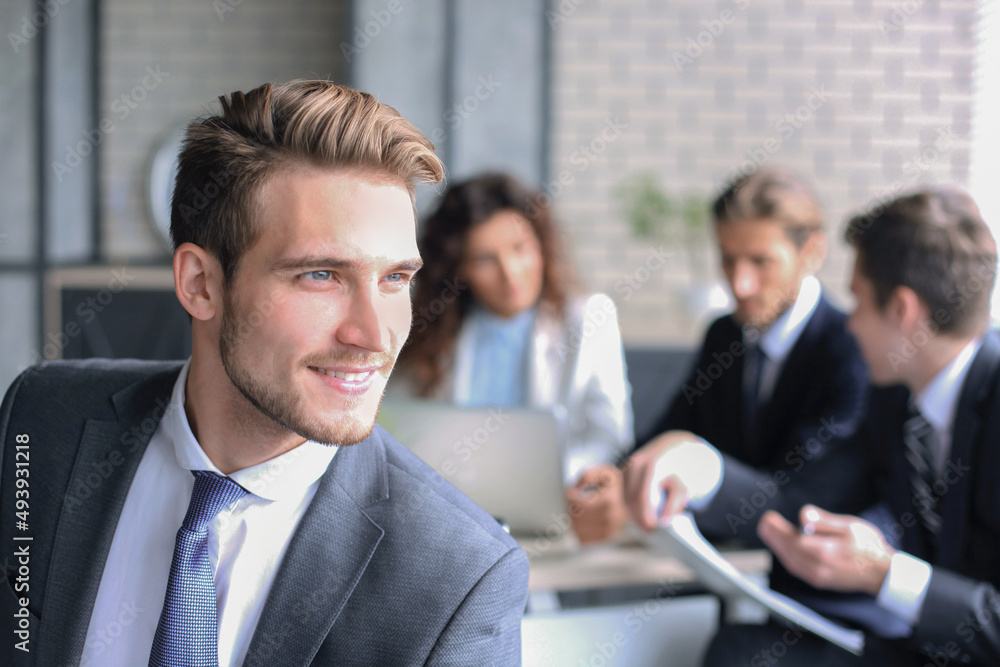 Businessman with colleagues in the background in office Businessman with colleagues in the background in office