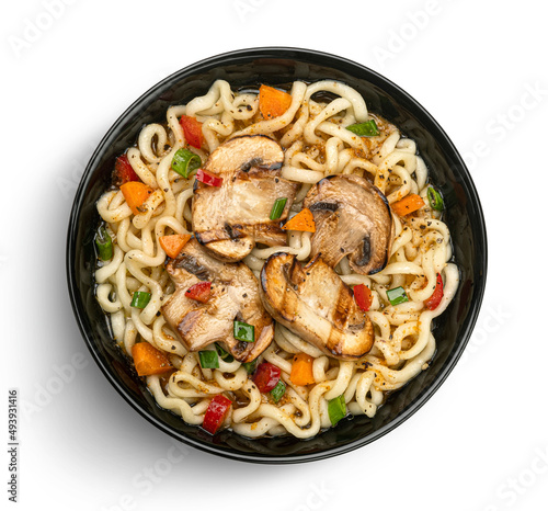 Instant noodles with grilled mushrooms in black bowl, top view