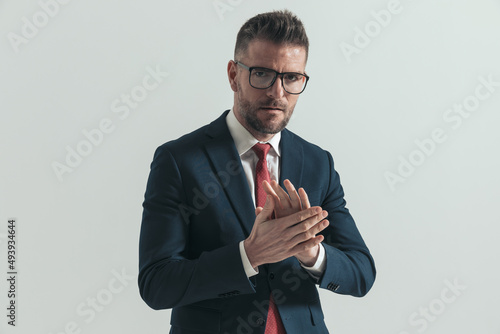 sexy man with eyeglasses and beard touching and rubbing palms