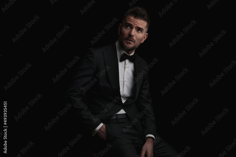thoughtful businessman looking up and holding hand in pocket thoughtful businessman looking up and holding hand in pocket