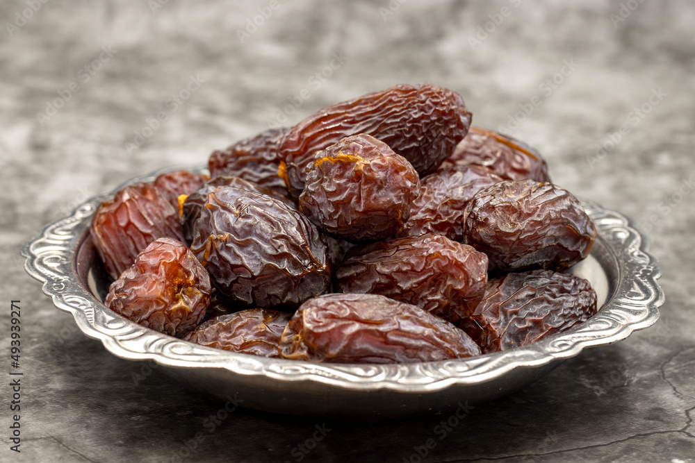 Date fruit on a dark background. Date fruits on a rustic serving plate Date fruit on a dark background. Date fruits on a rustic serving plate
