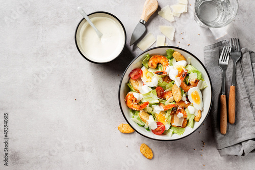 Fresh Shrimp Caesar Salad with parmesan cheese and Croutons. Gray background, top view, space for text. 