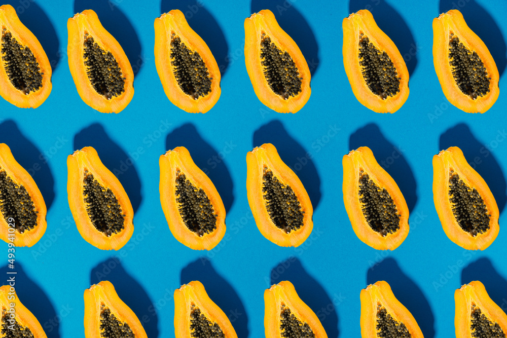 papaya fruit cutted on half on blue background pattern