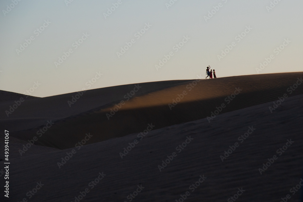 silhouette of people in the dunes