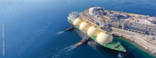 Aerial drone ultra wide panoramic photo with copy space of LNG (Liquified Natural Gas) tanker anchored in small gas terminal island with tanks for storage photo