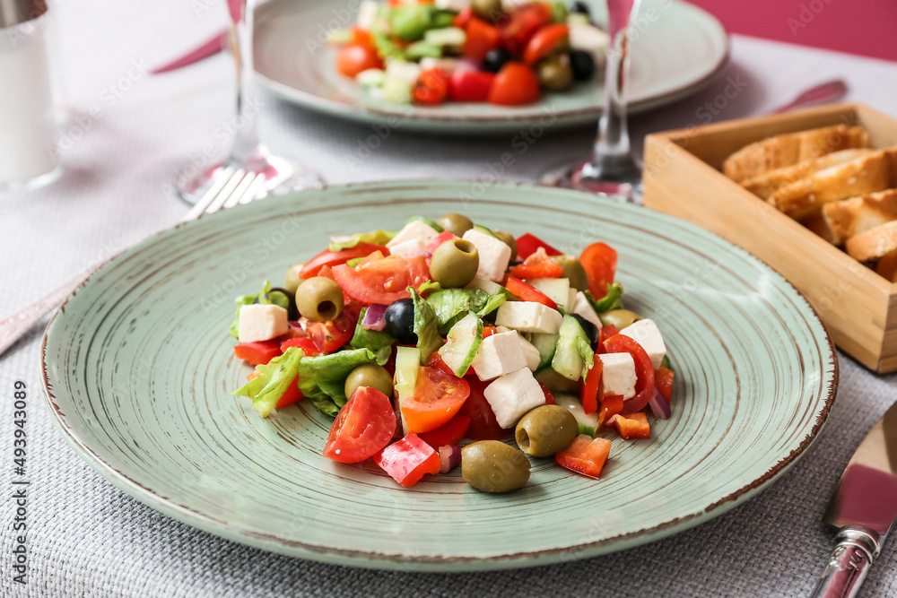 Plate with healthy Greek salad on table in restaurant Plate with healthy Greek salad on table in restaurant