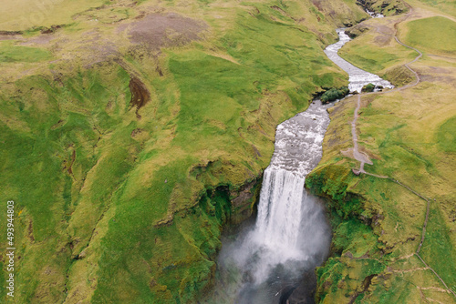 Skogafoss waterfall with river above in summer. Birds eye view from drone. Iceland.