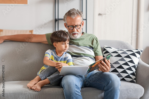 Senior man reading story to...