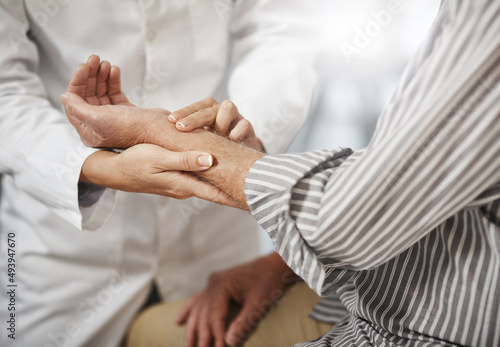 Lets check your pulse. Cropped shot of an unrecognizable female doctor taking a male patients pulse during a consultation.