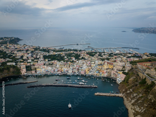 Colored boats anchored at small seaside town quay (aerial drone photo). Mediterranean, Procida, Italy