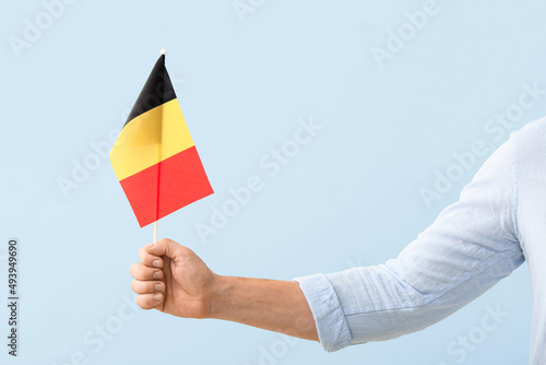 Male hand with Belgian flag on light background
