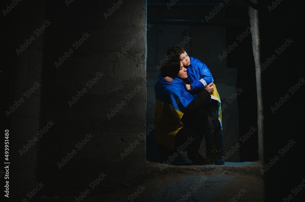 Sad mother hugging her son, both wearing Ukrainian national colors on black background. Sad mother hugging her son, both wearing Ukrainian national colors on black background.