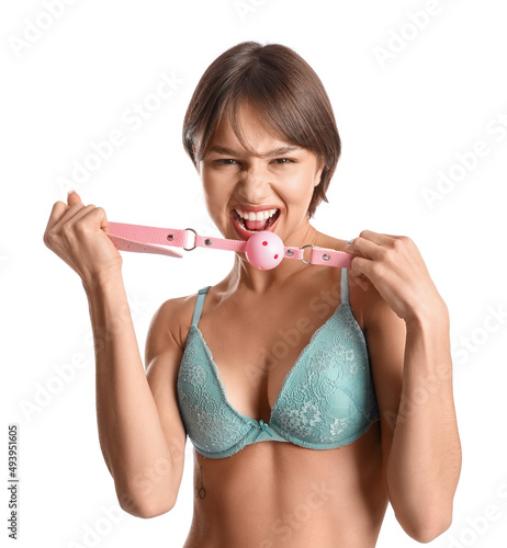 Beautiful young woman with mouth gag on white background