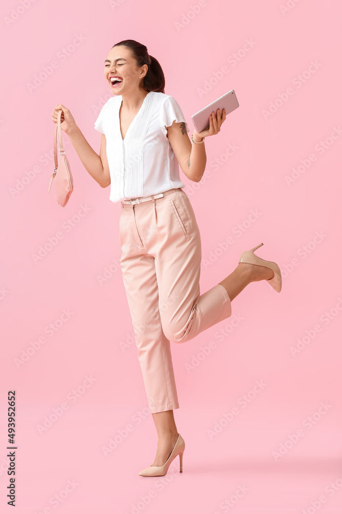 Happy young businesswoman with tablet computer and bag on pink background Happy young businesswoman with tablet computer and bag on pink background