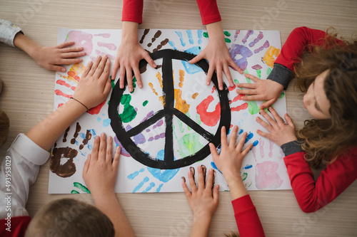 Fotografía Top view of children making a poster of peace sign at school.
