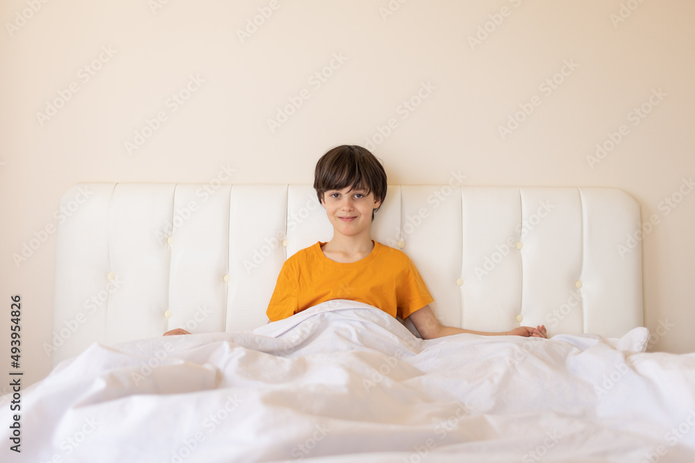 The child woke up and sits on the bed The child woke up and sits on the bed