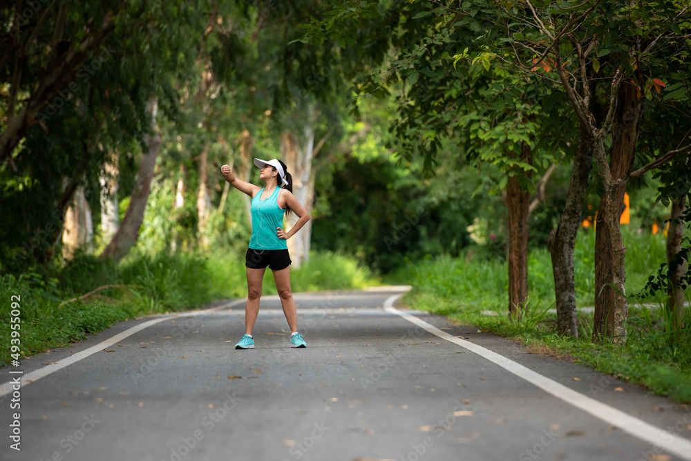 Healthy woman jogging run and workout on road outdoor. Asian runner people exercise gym with fitness session, nature park background. Health and Lifestyle Concept Healthy woman jogging run and workout on road outdoor. Asian runner people exercise gym with fitness session, nature park background. Health and Lifestyle Concept