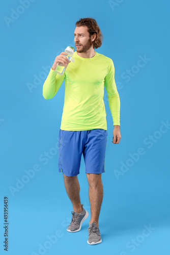 Sporty man with bottle of w...