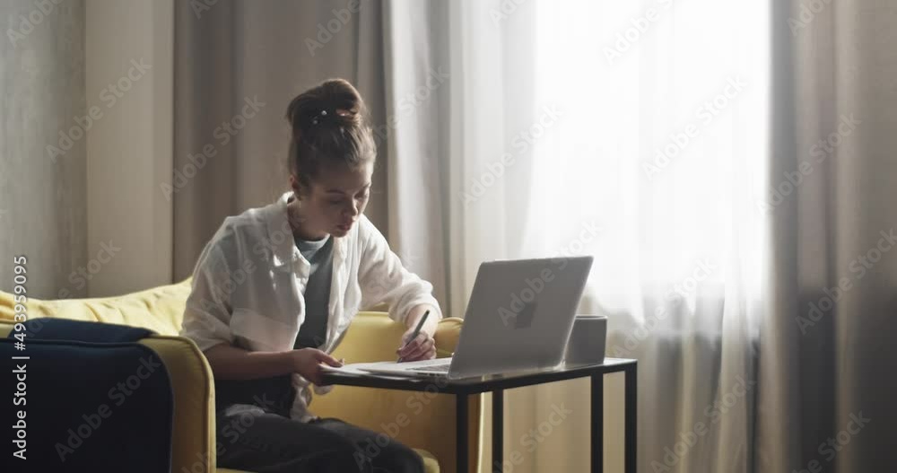 Student taking notes during remote lesson via laptop Student taking notes during remote lesson via laptop