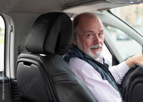 Fotografiet portrait of an elderly driver in car or taxi